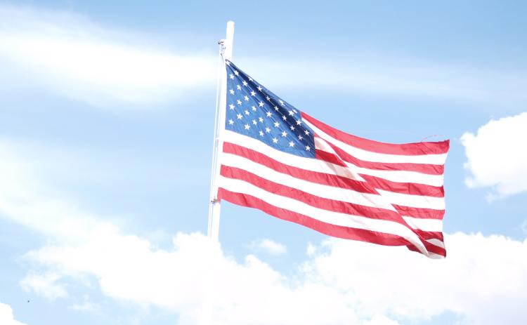Old Glory, raised by the Free in honor of the Brave, presides over the Wichita County Fair Carnival.