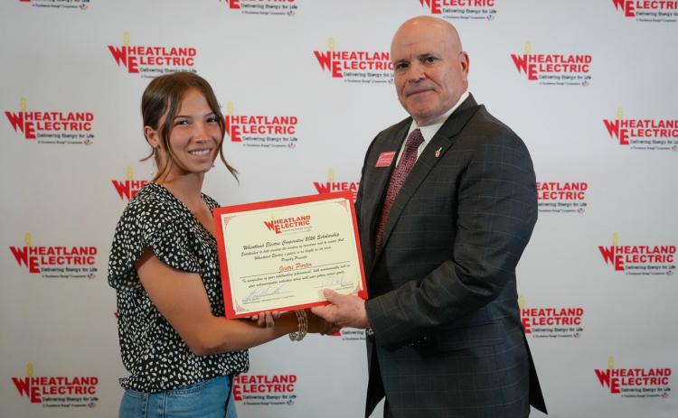 Bruce W. Mueller (right), CEO/general manager of Wheatland Electric Cooperative, Inc., awards Jentri Porter (left), a senior at Wichita County High School, with a $1,000 scholarship during WEC’s annual meeting in Great Bend, Kan. on April 22.