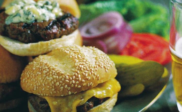 The best garnishes for burgers are the classics: a slice of ripe beefsteak tomato, a mound of sautéed onions, a leaf of romaine lettuce, a dollop of coleslaw, or a few slices of dill pickles.