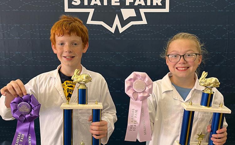 Pictured: Reid Marcy (left) and Lyvia Imler (right) proudly display their Grand and Reserve Champion trophies from the Kansas State Fair Rabbit Showmanship Contest.