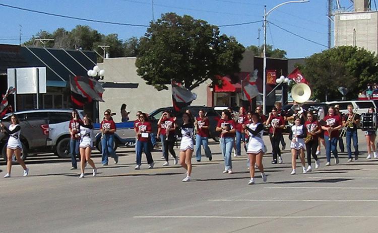 The Fall Cheer Squad and the marching band lead the Homecoming Parade down 4th Street on Friday.