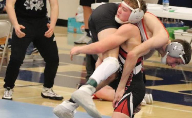 Above: Wyatt Gardner (in singlet, standing) makes a monster move during a match at the sub-state tournament in Minneapolis, KS, on Saturday, February 20, causing his older brother, Jesse Gardner (L), to erupt in a raucous cheer. Photo credit Maggie Brown