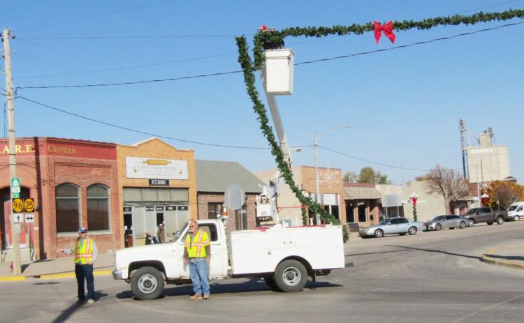 City of Leoti crew members Adam Marcotte and Mike Craven while Filemon Ponce (in the bucket) strings garland across the keep an eye on the traffic situation (I promise there was some!) intersection of 4th and Broadway streets on Tuesday morning.